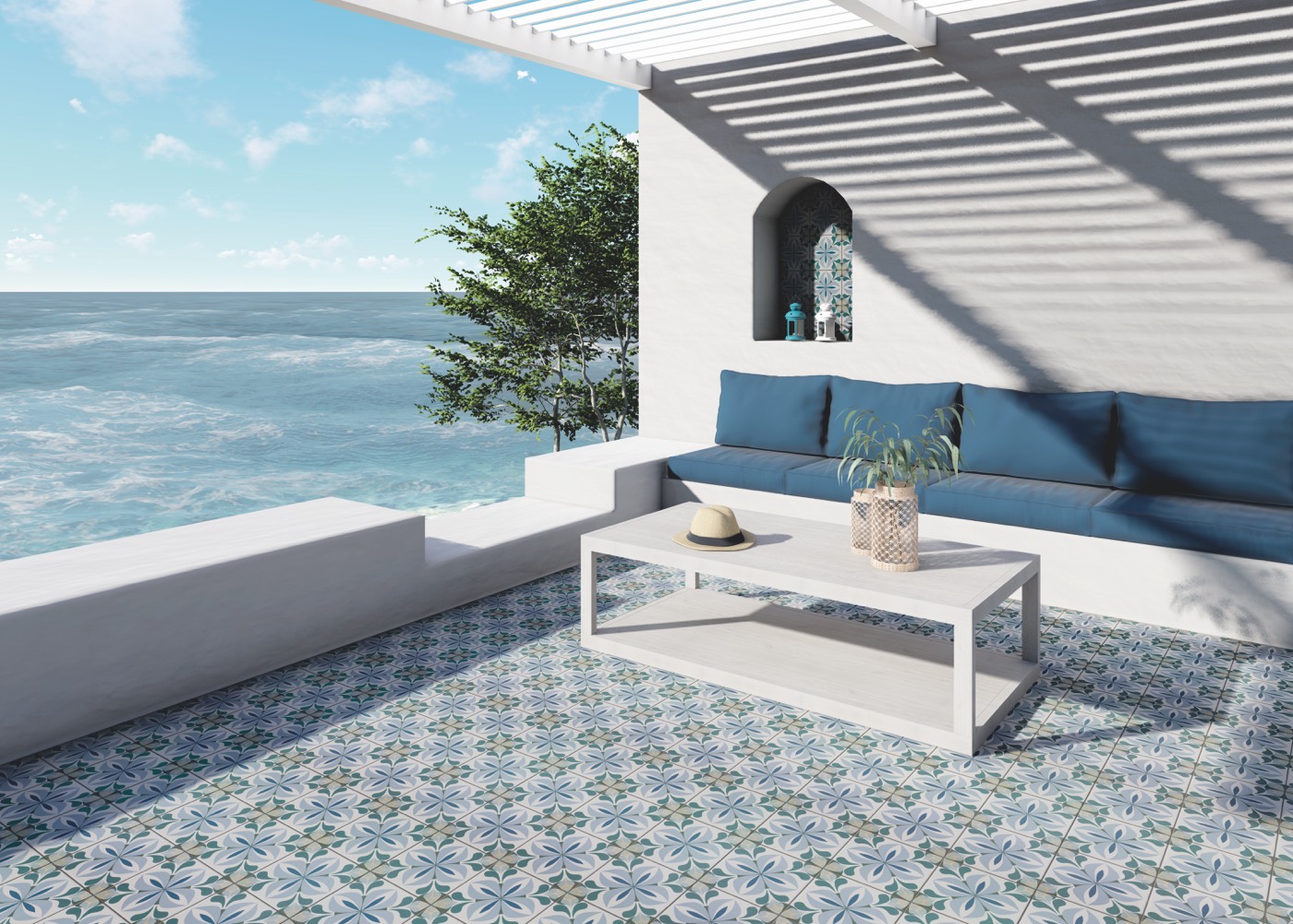 Terraza frente al mar con sofá de obra y pavimento efecto hidráulico con motivos florales azules y verdes